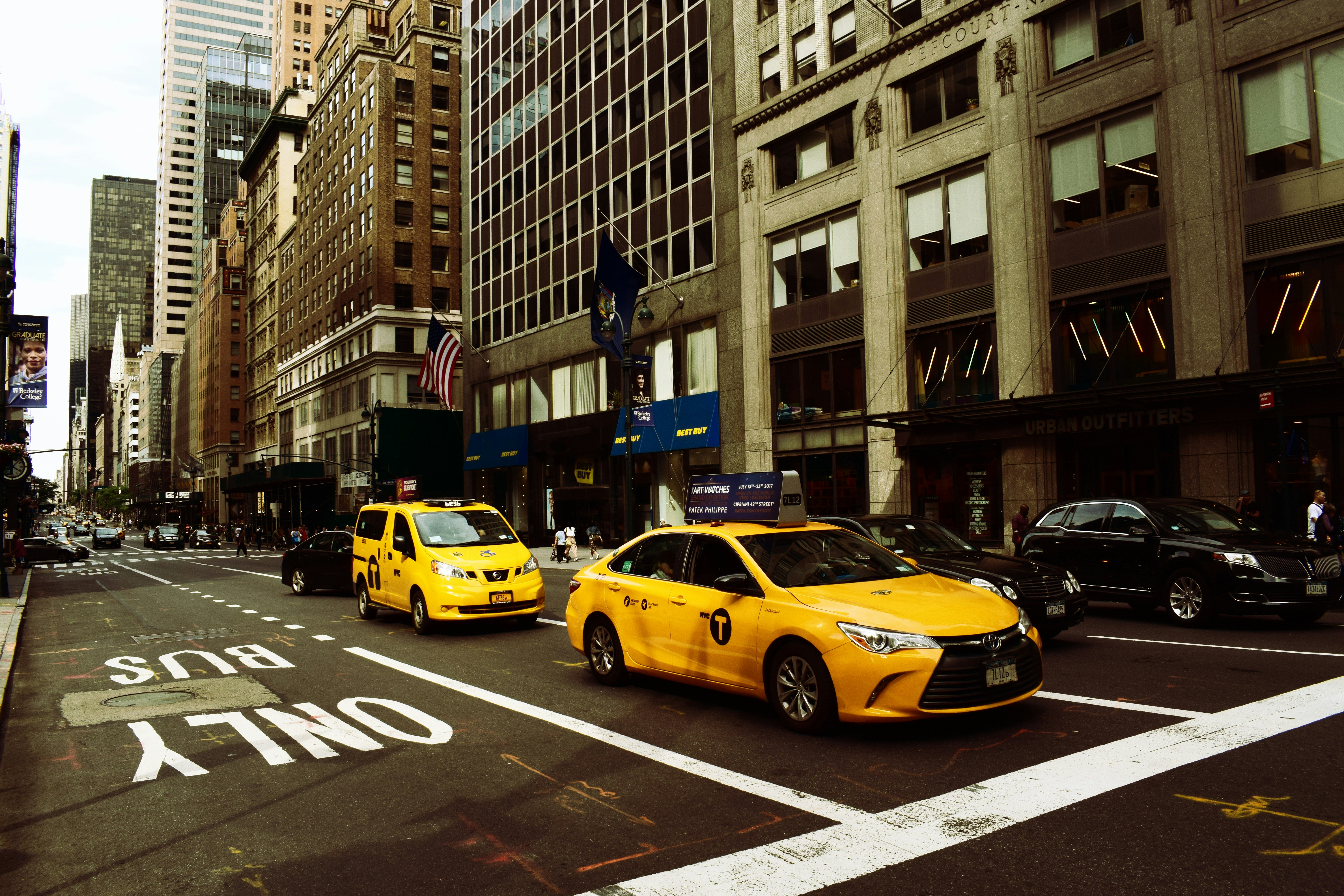 two yellow taxis on middle of road